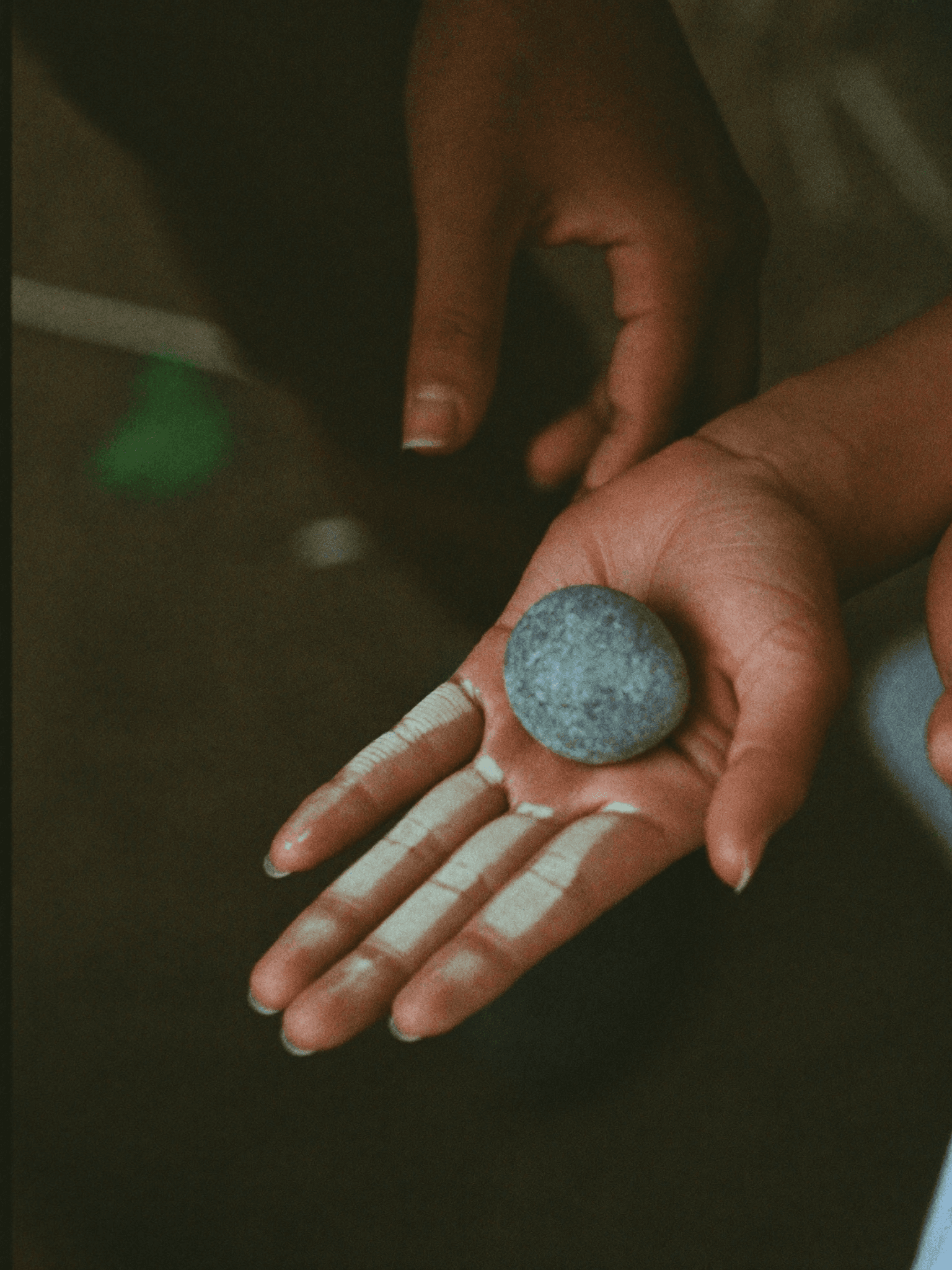 a small hand turning over a stone